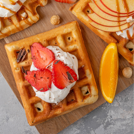 En AI genererad bild av en våffla med grädde och jordgubbar på toppen.